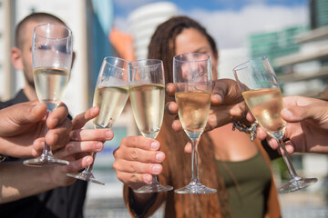 Close-up of misted champagne glasses. People of different nationalities holding cold champagne in flutes. Teambuilding, party concept