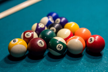 Billiard balls in a green pool table, ready for recreational activity