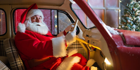Portrait of santa claus driving a red car for christmas. © Михаил Решетников