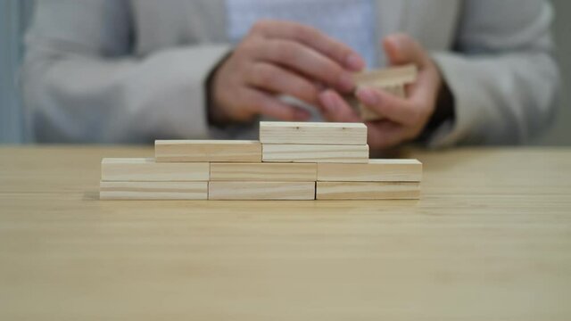 Close up Businesswoman arranging wood block stacking as step stair. Business concept growth success process.