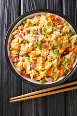 Yangzhou fried rice Traditional Chinese food close up in the plate on the table. Vertical top view from above