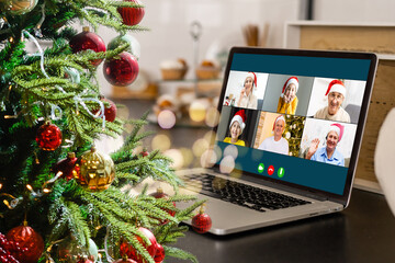 video call with happy diverse children on laptop computer in his workshop. Self-isolation and virtual online celebration at home concept. Christmas