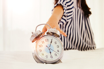 Women and modern life : Girl woke up in the morning with an alarm clock : teenage girl sitting on a...