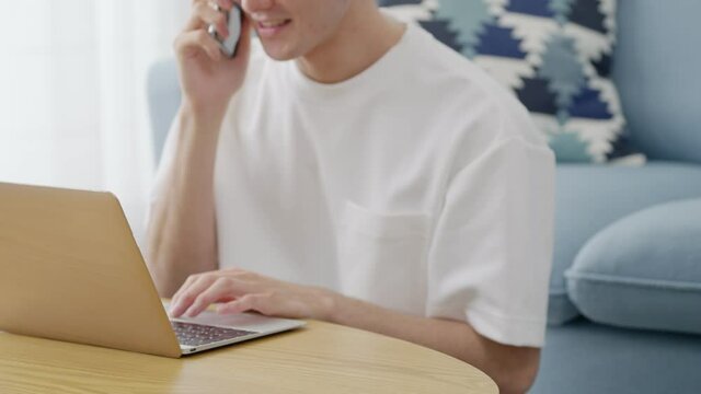 家でパソコンを使い仕事をする若い男性（ビジネスイメージ）