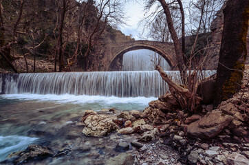 Historical stone bridge of Palaiokarya with its two artificial waterfalls situated close to Trikala and Meteora.