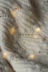 Light knitted jumper, with New Year's lights, Christmas background.