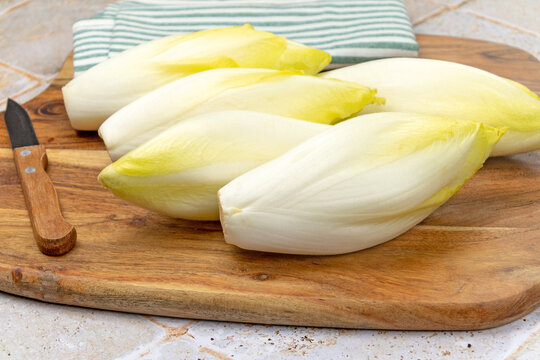 plusieurs endives crues sur une planche de bois