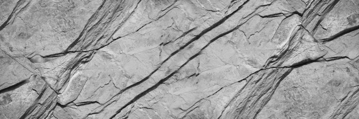 Black white rock texture. Mountain surface. Close-up. Gray stone background with copy space for design. Wide banner.