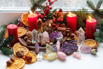 Gemstones crystals, candles and natural winter decor on windowsill. Witchcraft esoteric Ritual with energy healing minerals. soul relax concept. Christmas, Magical Winter Solstice
