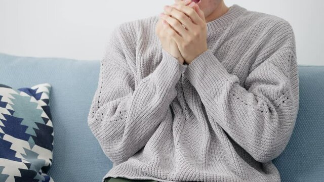 リビングで寒がる若い男性