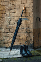 Men's shoes with an umbrella and a walking stick are on the street