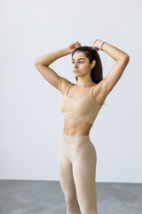 Fototapeta premium Sporty slim woman with ponytail fitness woman enjoys workout exercise on white background