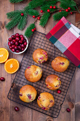 Cranberry orange muffins on cooling rack, vertical, top view, Christmas decoration on background