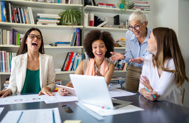 Group of happy business people working together on new project in corporate office.