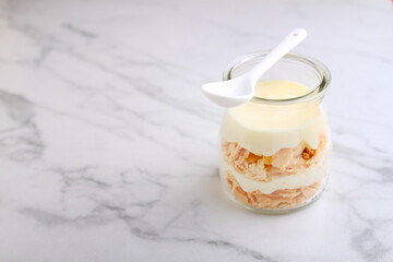 Napoleon cake with cream in small vintage jars on marble background.