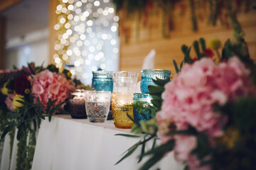 Wedding decor on table made of flowers, candles and beautiful bokeh. High quality photo