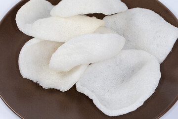 Rice chips close-up on the brown dish