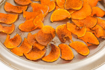 Homemade pumpkin chips on the baking sheet close-up