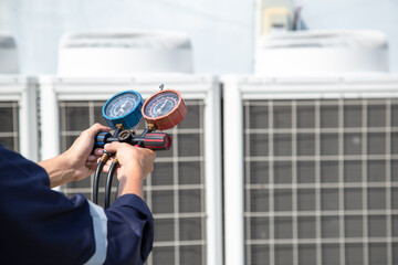 Technician is checking air conditioner ,measuring equipment for filling air conditioners , service and maintenance air conditioner .