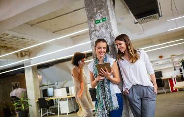 Attractive businesswoman having fun conversation with colleague during break in office