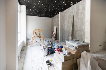 The wall of the building is covered with fresh plaster and surrounded by construction. Background.