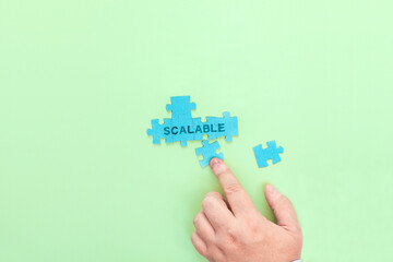 Businessman connecting puzzle pieces with the word Scalable
