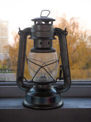 Kerosene lamp on the window overlooking the autumn trees 