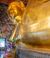 One of the world's largest reclining Buddha statues at the Wat Pho Buddhist Temple in downtown Bangkok Thailand