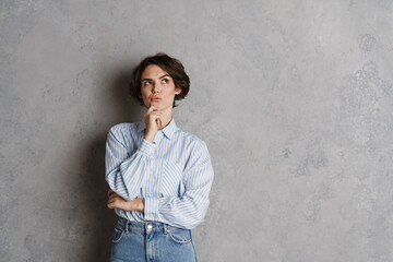 Young brunette woman holding her chin and looking upward