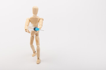 wooden mannequin with syringe against white background