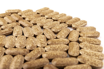 Nutrition supplements, brown vitamin pills on white background.