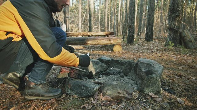 Man's Hands with a Knife Cut Shavings for Lighting a Fire. Survival in the Wild. Man with a Knife in the Woods. Survival Concept