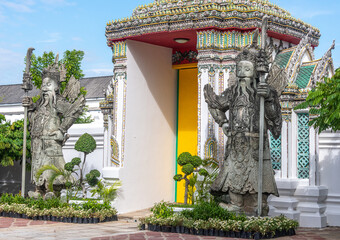 Statues at a doorway at Wat Pho Buddhist Temple in downtown Bangkok Thailand