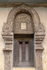 Detail of ancient traditional stucco decoration on window frame of historic hor trai library in Wat Duang Dee buddhist temple, a religious landmark of Chiang Mai, Thailand