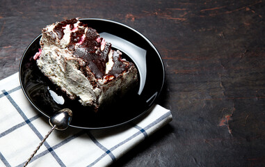 Plate with slice of tasty chocolate cake on table. Yummy dessert on on wooden background, closeup