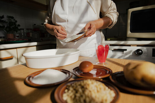 Woman with ingredients preparing panellets in kitchen