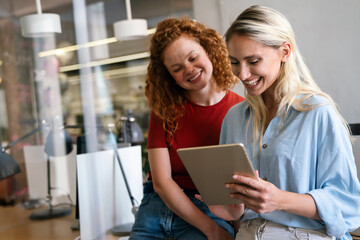 Portrait of happy young business women, designers smiling while working together in office