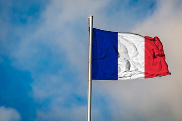 A Flag of France flying on a Flagpole against the Sky