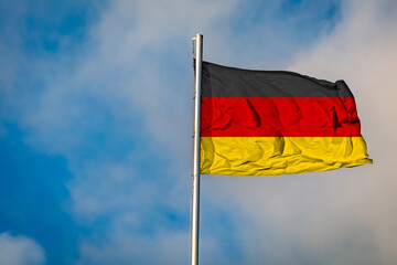 A Flag of Germany flying on a Flagpole against the Sky