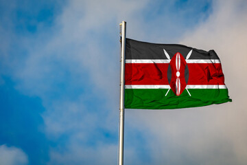 A Flag of Kenya  flying on a Flagpole against the Sky