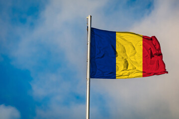 A Flag of Romania flying on a Flagpole against the Sky