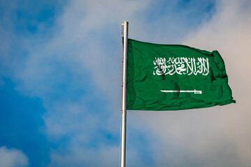 A Flag of Saudi Arabia flying on a Flagpole against the Sky