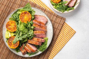 Salad with roasted duck breast and grilled orange tangerines. Natural organic nutrition.