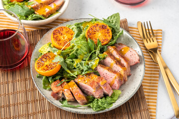 Fototapeta na wymiar Salad with roasted duck breast and grilled orange tangerines. Natural organic nutrition.