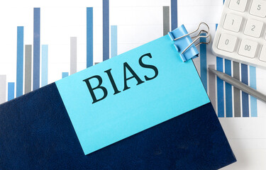 BIAS on sticky note on notebook on the chart background