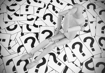 People problems concept. Wooden figurine on question marks background.	
