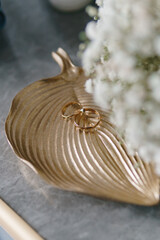 Wedding rings on a gold plate in the form of a leaf