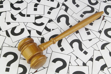 Legal consultation concept. Judge's gavel on question marks background.	