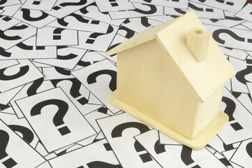 Rent, buy and sell house questions concept. House model on question marks background.