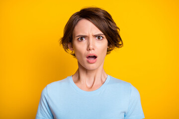 Photo of young brown hair woman unhappy shocked amazed fake novelty rumor news isolated over yellow...